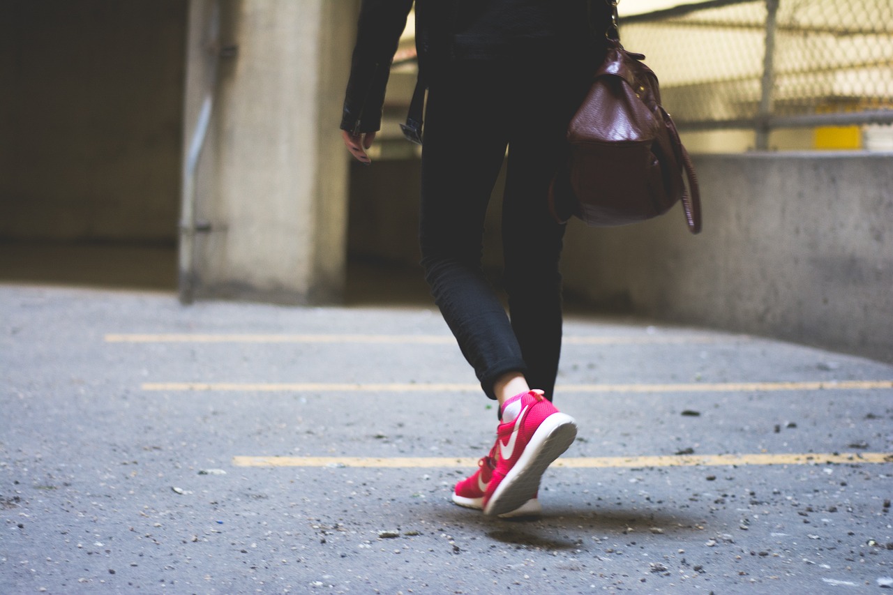 vue sur les pieds d'une femme portant des baskets rouges et un pantalon noir